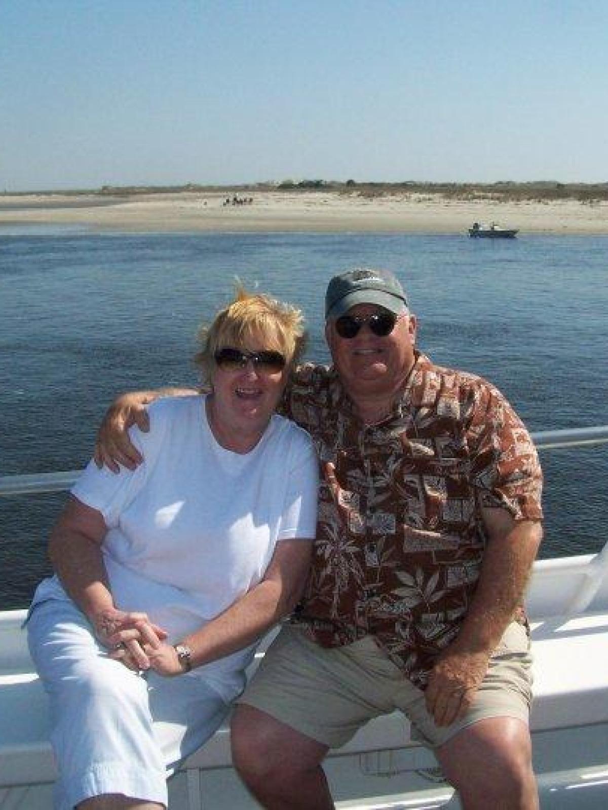 a man and woman sitting next to a body of water